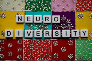 image showing a patterned tile background, on which sit Scrabble-style letters reading “Neurodiversity”