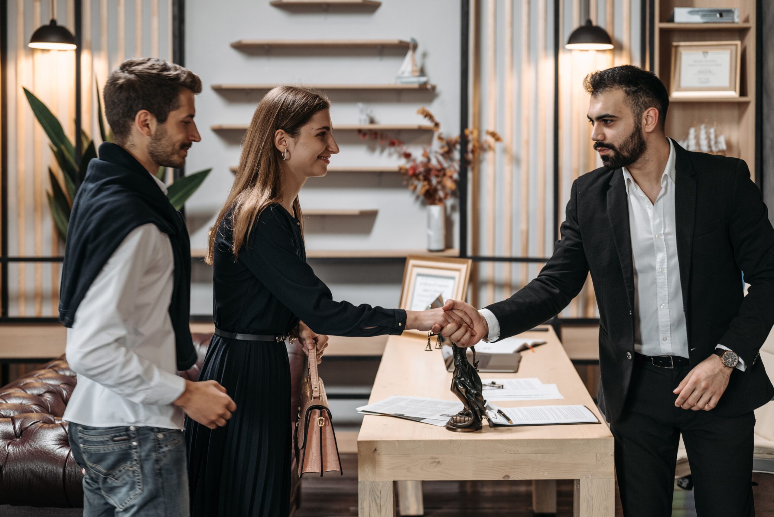 image shows two people greeting another person in an office setting